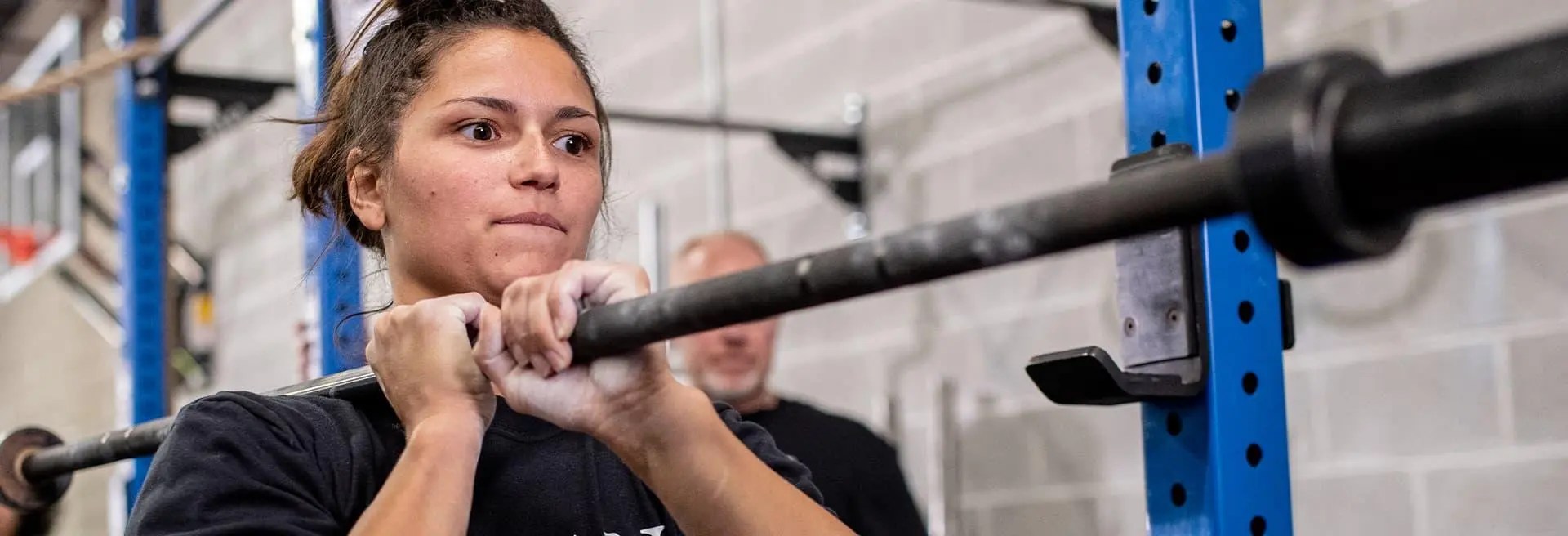 Student lifting a barbell in the gym