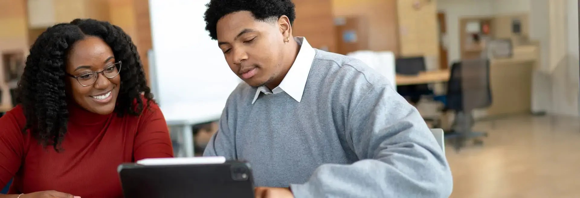 A man and a woman looking at a laptop